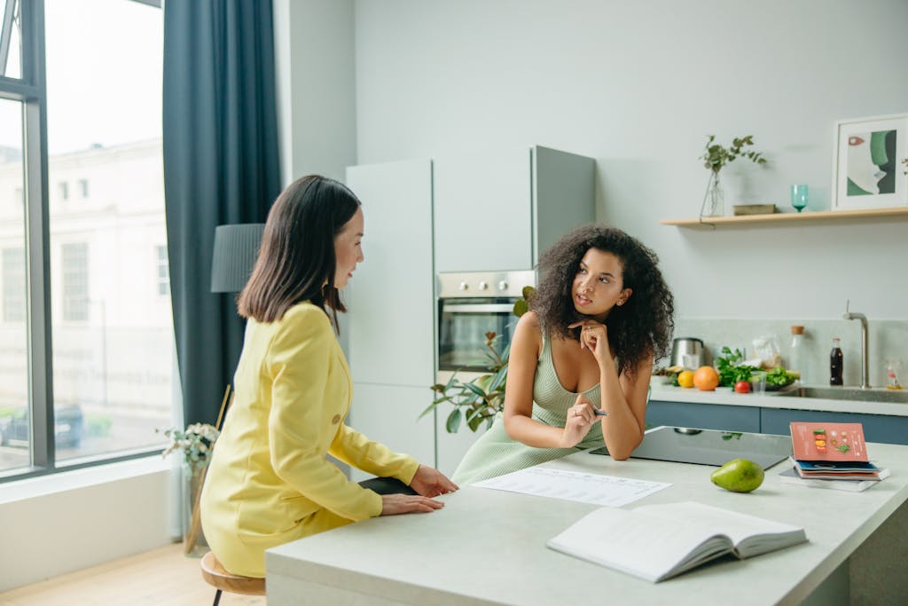 Two women engage in a conversation about nutrition in a stylish kitchen setting.